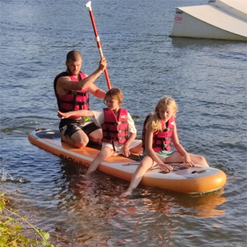 deux enfants sur un paddle accompagné d'un adulte